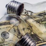 A lightbulb on dollar bill, energy saving concept