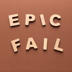 Epic fail phrase spelled with wooden letters on brown background, copy space, top view. Crisis, failure, social media and contemporary slang concept
