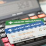 Medical insurance cards on the calculator. Health care costs con